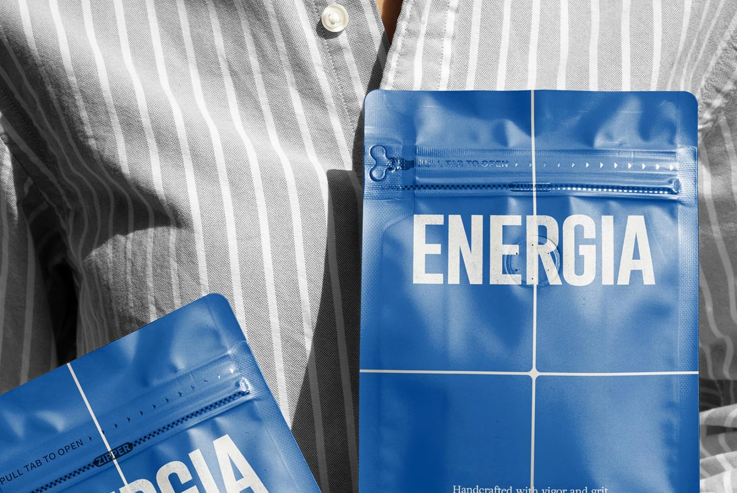 Overhead shot of striped shirt with two blue ENERGIA packets on fabric surface