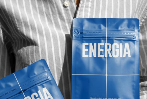 Overhead shot of striped shirt with two blue ENERGIA packets on fabric surface