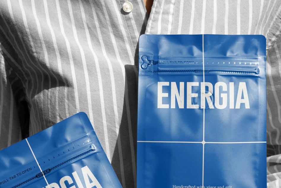 Overhead shot of striped shirt with two blue ENERGIA packets on fabric surface
