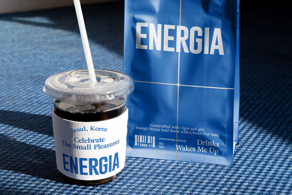 Clear cup with white straw, blue carton nearby on blue fabric in daylight