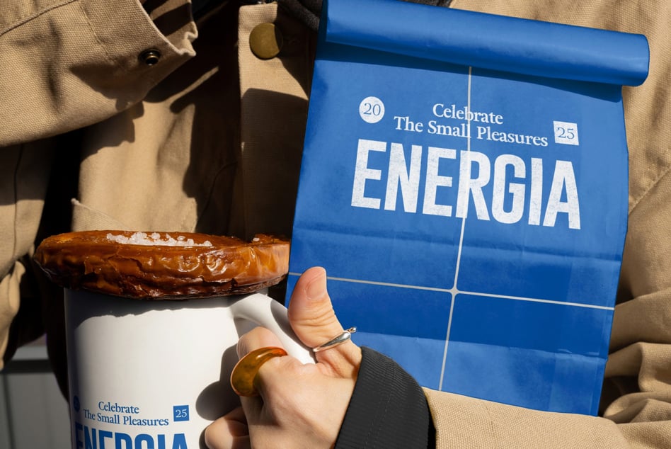 Blue paper bag mockup with Energia branding next to white mug with pastry