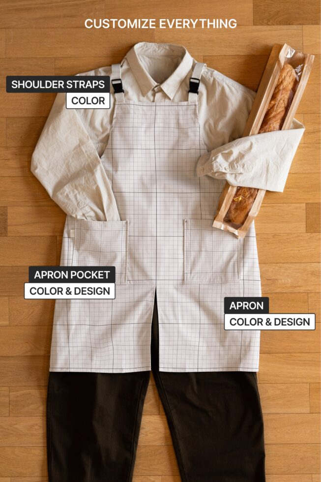 Cream apron with grid pattern shown flat lay with labeled customizable parts