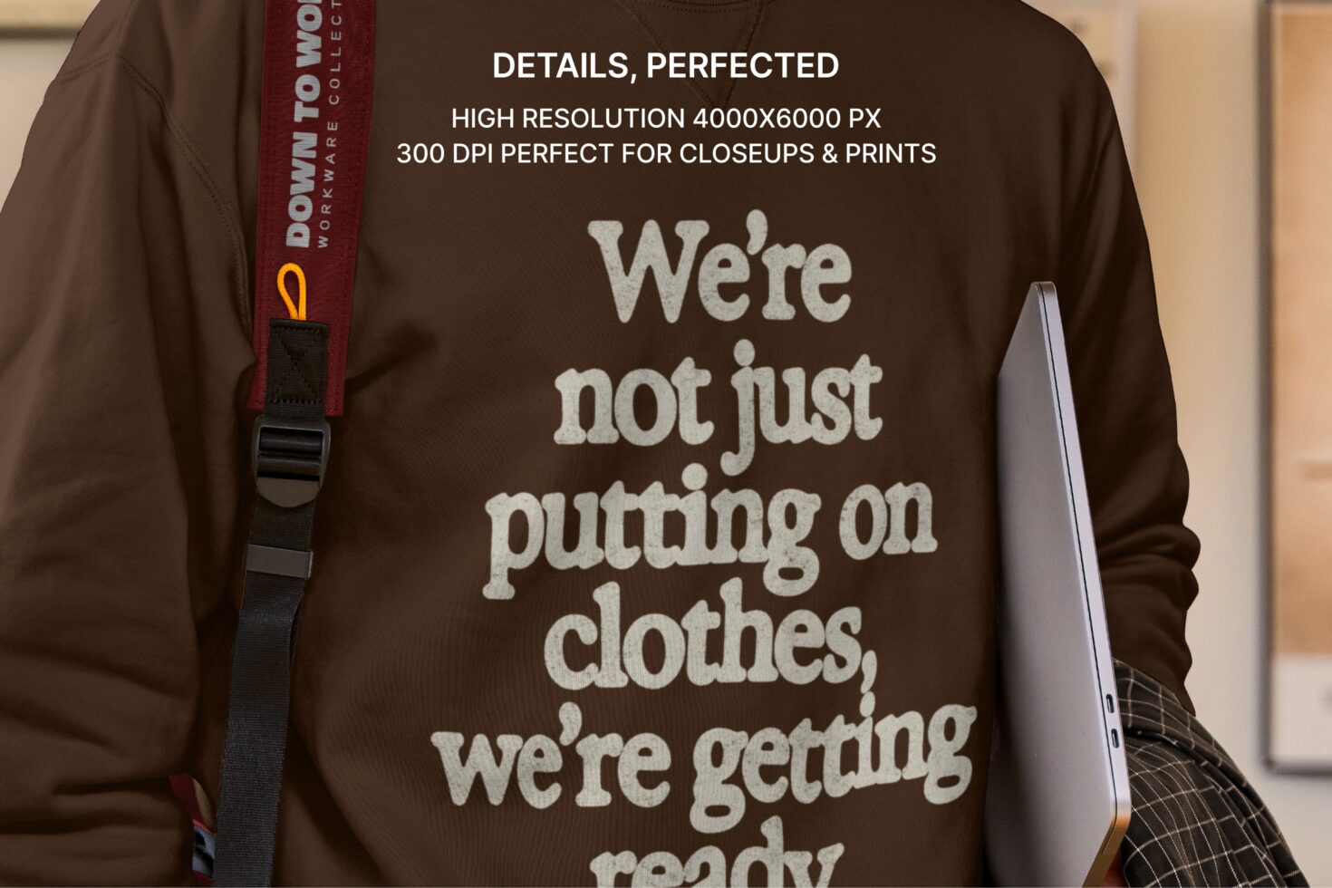 Brown sweatshirt with cream text graphic, worn with laptop shoulder bag