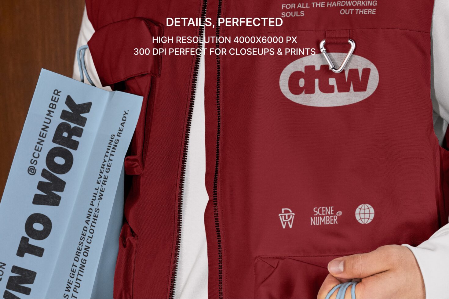 Close up of burgundy vest with dtw logo patch, white zipper detail visible on model