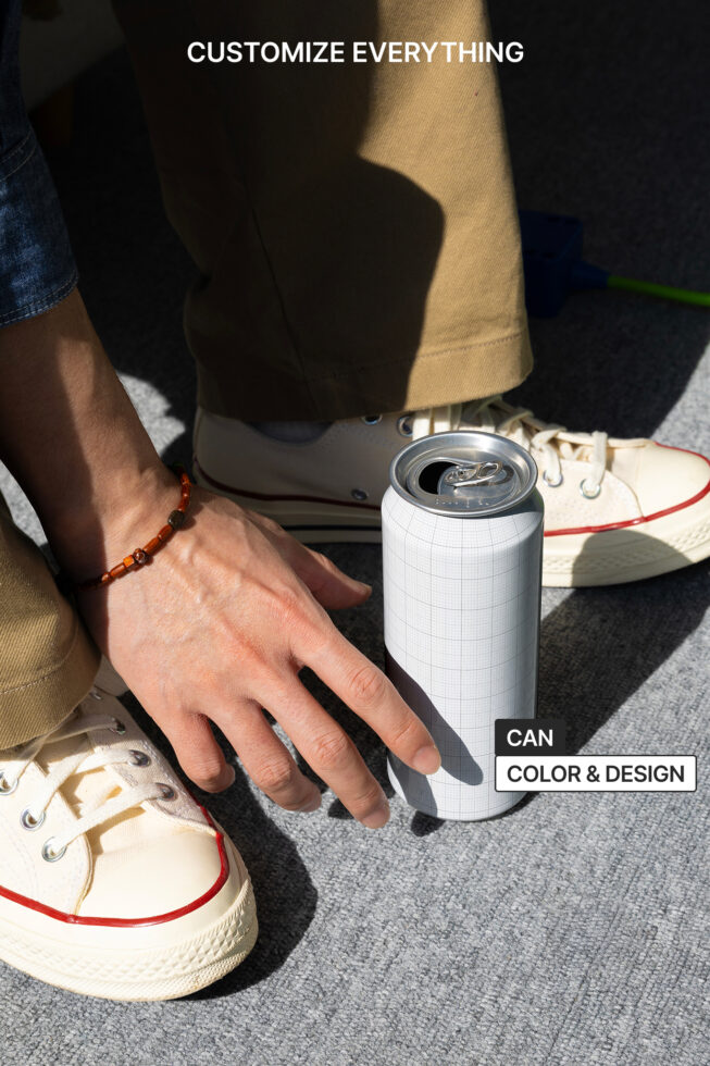 Blank can mockup in hand next to sneakers on ground