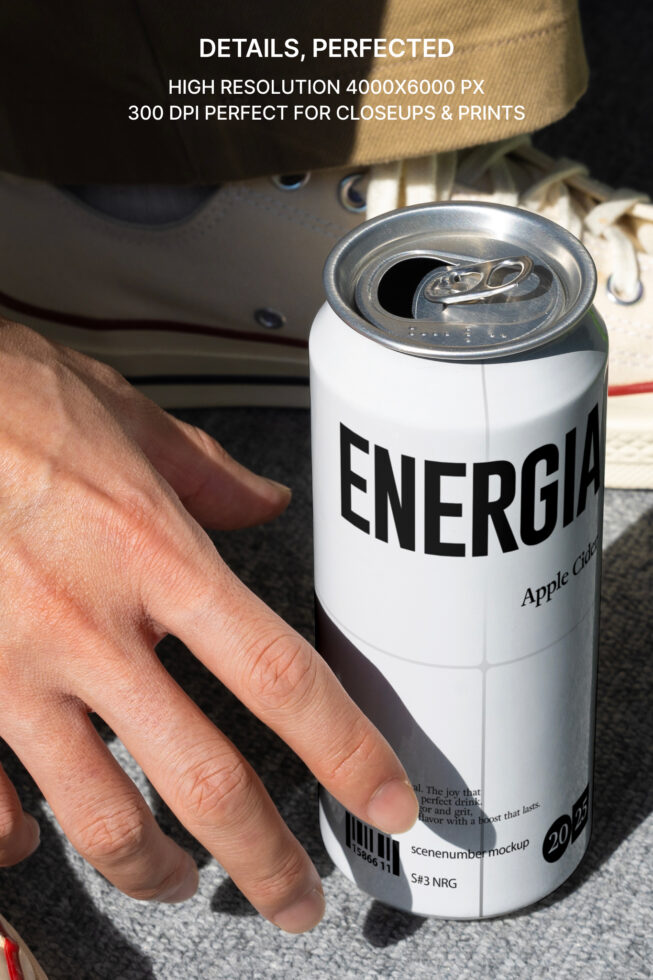 Open pull-tab on white Energia can held in palm outdoors