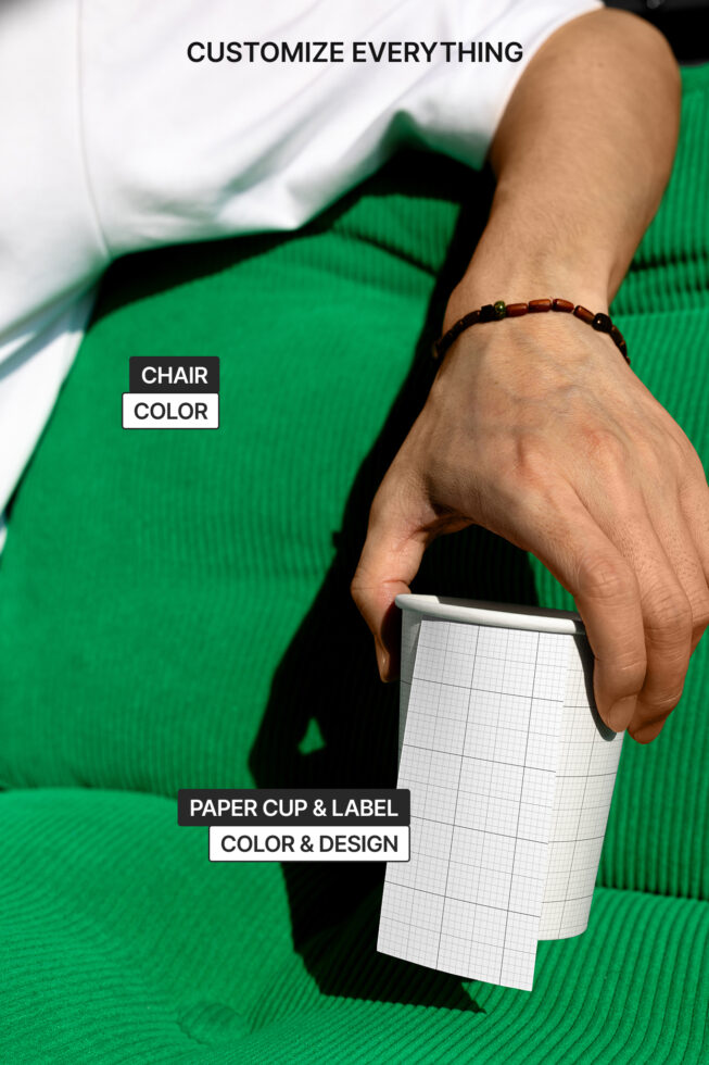 Person sitting on green chair holding paper cup mockup with customizable label design