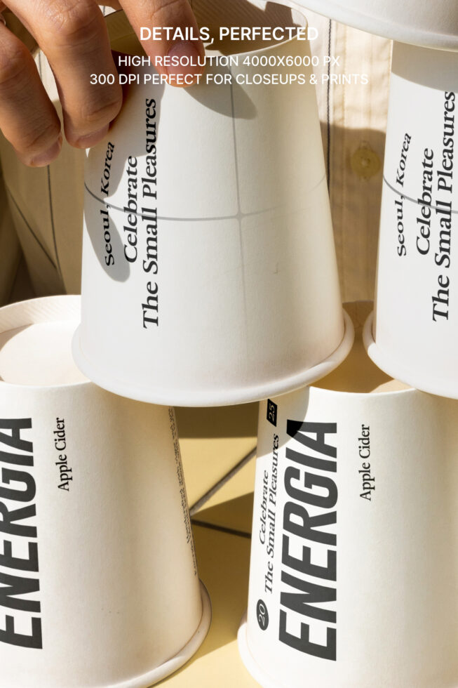 Multiple cream paper cups stacked showing side label text in detail shot