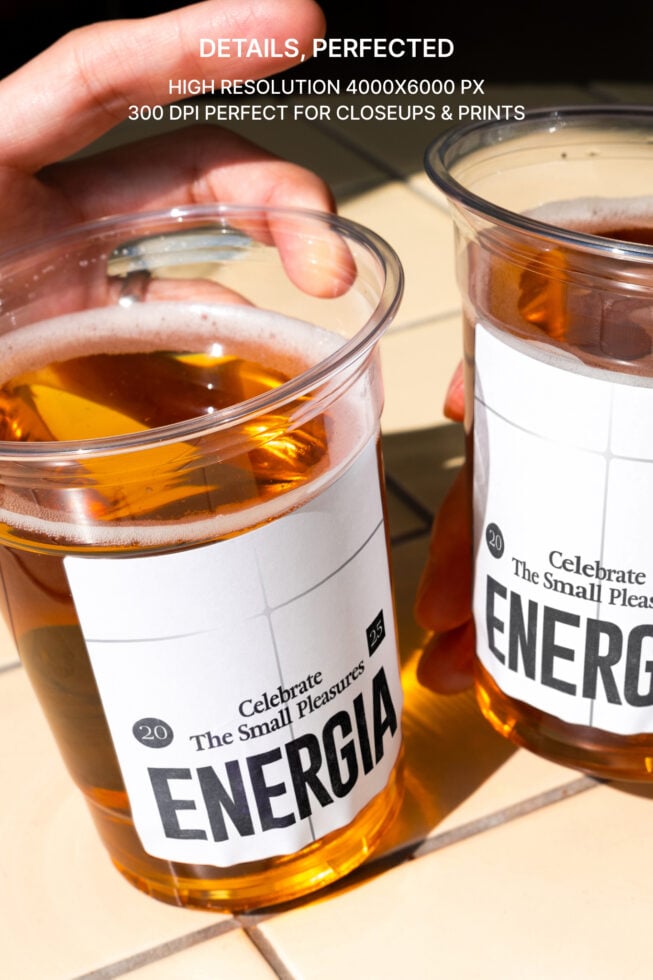 Two Energia cups filled with cola held in hands showing label detail