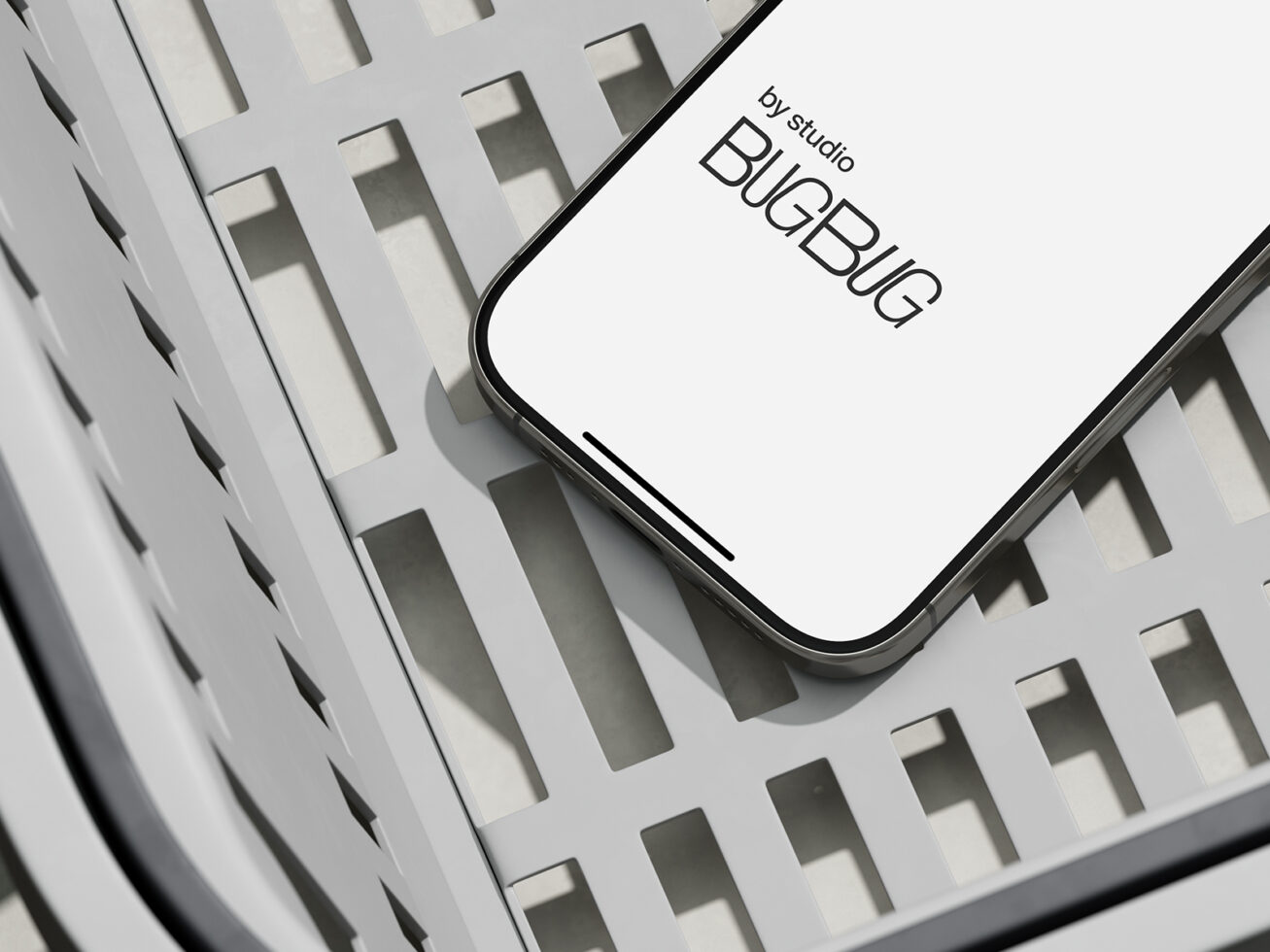 Overhead view of iPhone with studio branding on white grid surface with sharp shadows