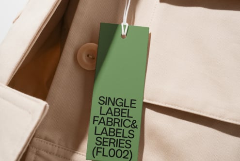 Green hang tag with black text on natural tan fabric with buttons