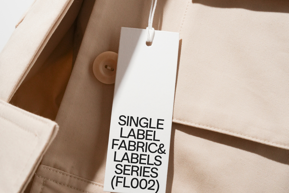 White hang tag with black text on beige cotton fabric material