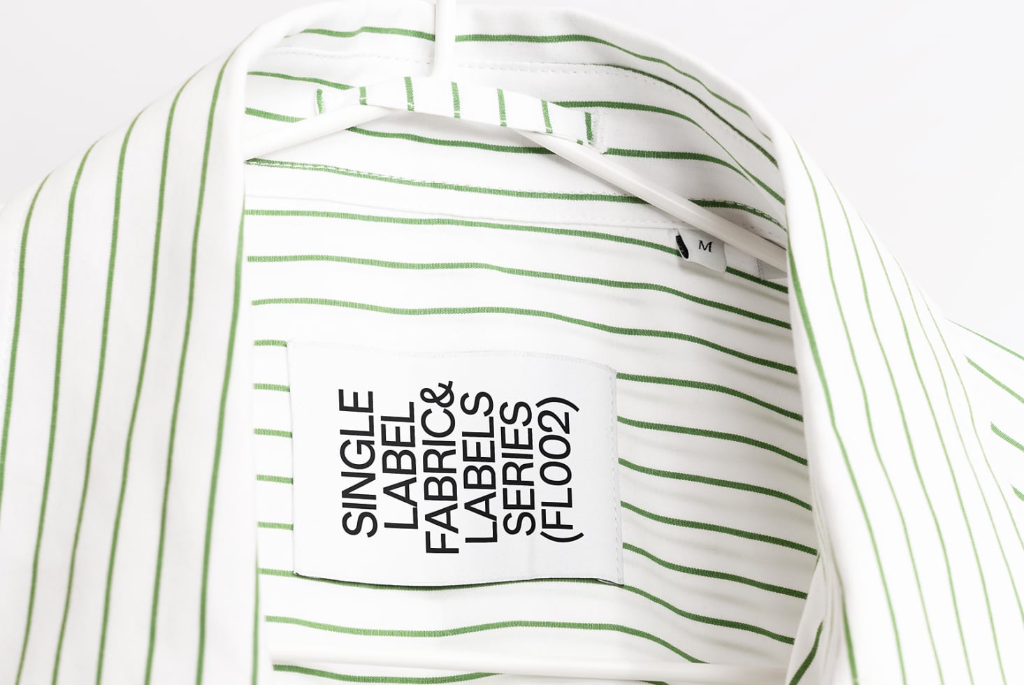 Striped white shirt with green lines displaying black text hang tag mockup
