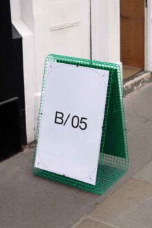 Green mesh A-frame sidewalk sign mockup with B/05 on white panel