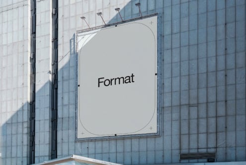 Light billboard on modern building facade with Format text centered in white