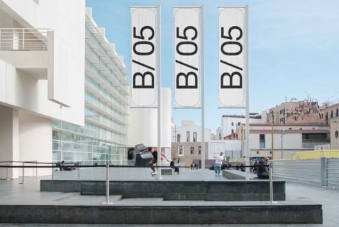 Three tall vertical banners on building facade overlooking plaza, text B/05
