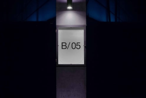 Blue-toned wall fixture with lit ceiling lamp, screen showing B/05 text