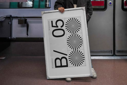 Person holding light poster mockup in train or bus interior