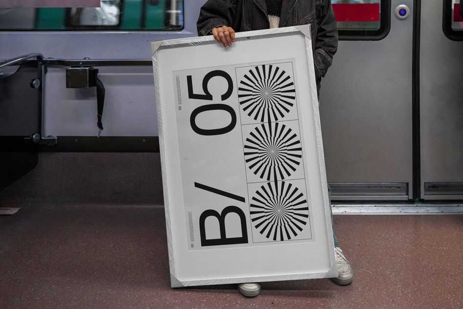 Person holding light poster mockup in train or bus interior