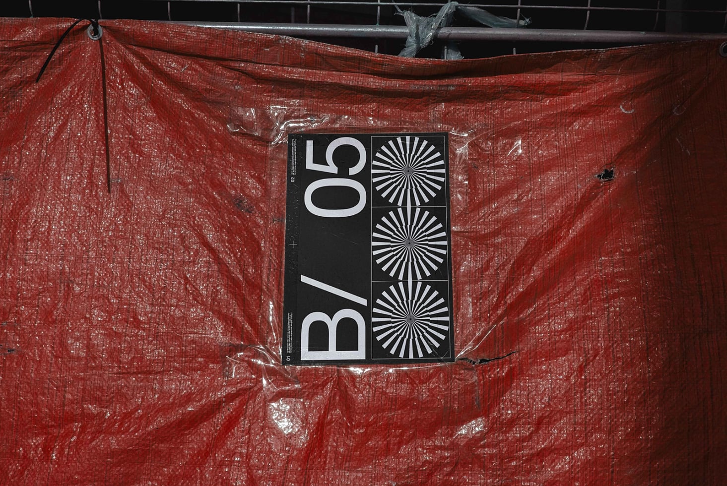 Poster mockup on red tarp with construction site backdrop