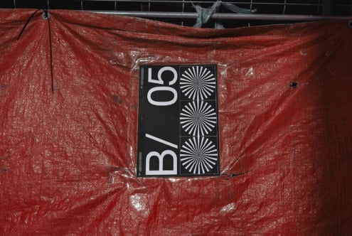 Poster mockup on red tarp with construction site backdrop