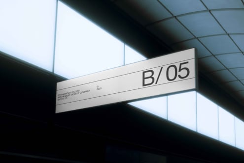 White horizontal suspended signage displaying B/05 in modern ceiling interior space