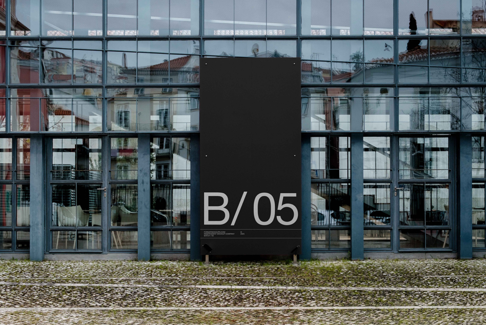 Dark vertical banner mockup with B/05 mounted on modern glass building storefront
