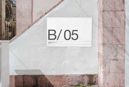 White horizontal sign mockup with B/05 text on weathered whitewashed stone wall