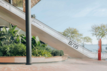 White diagonal banner mockup on curved modern building with ocean view