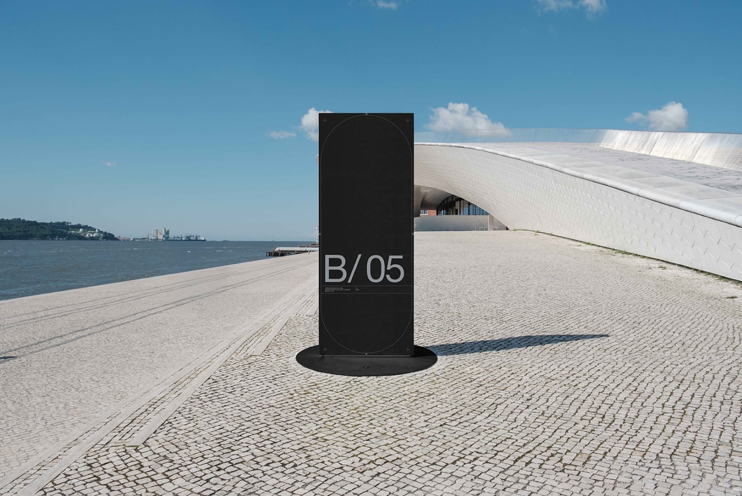 Black vertical sign mockup on waterfront promenade overlooking harbor