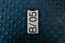 Smartphone on blue-gray diamond plate surface, white screen with B/05