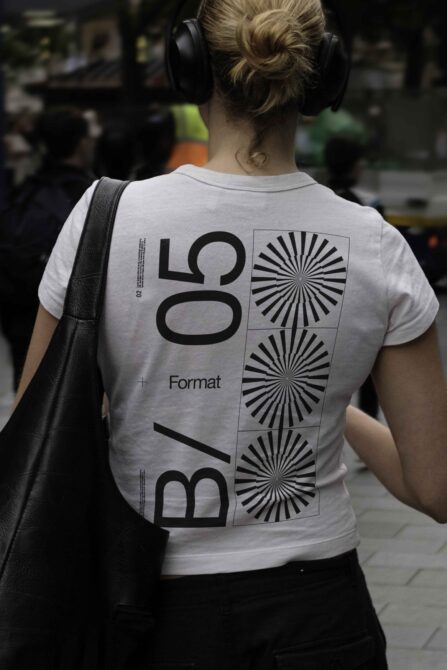 Person wearing light tee with bold geometric type layout on back