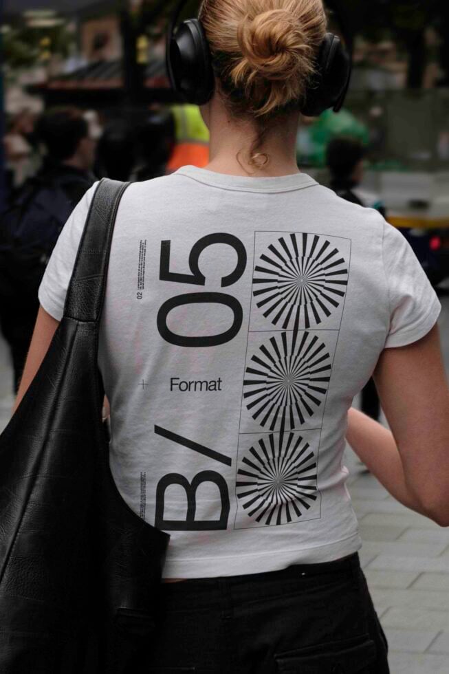 Person wearing light tee with bold geometric type layout on back