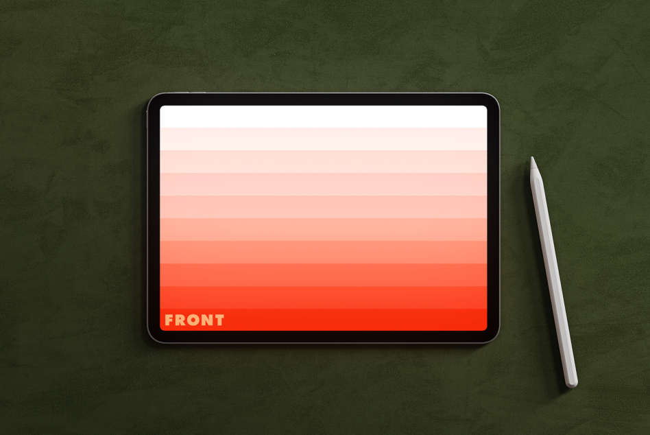 Tablet on green surface displaying coral gradient with stylus pen nearby