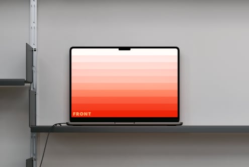 Laptop on shelf showing coral to red gradient display with text overlay