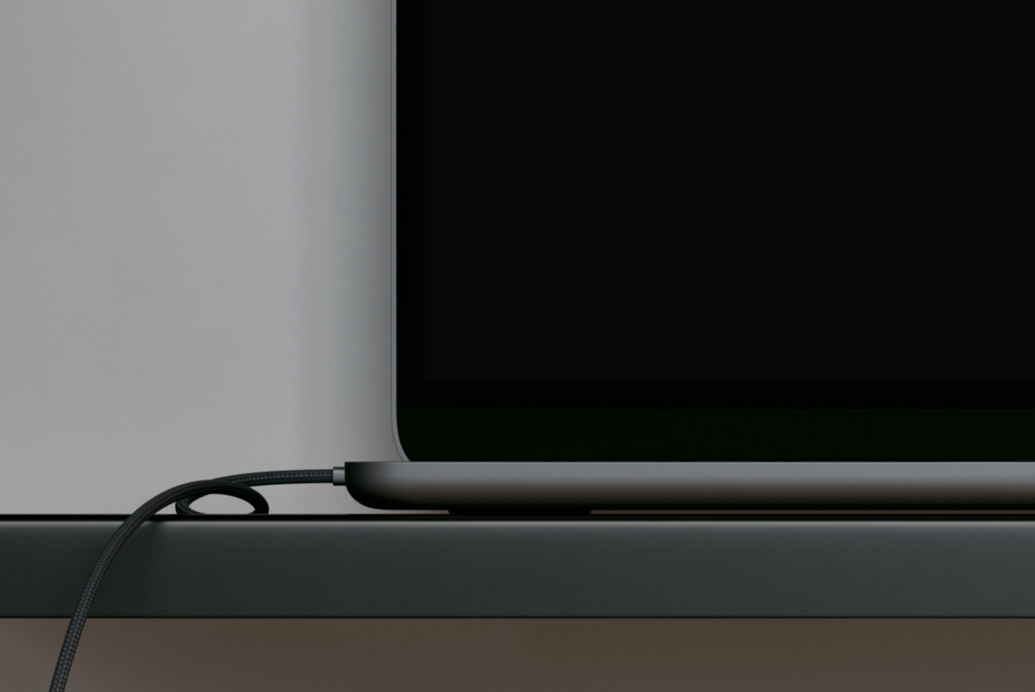 Tablet showing blank black screen on desk with cable