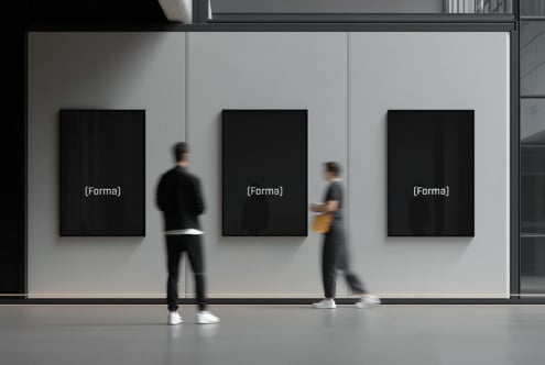 Three blank black framed posters on gallery wall with blurred passersby