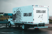 Light blue box truck mockup featuring gorilla hunt design parked outdoors