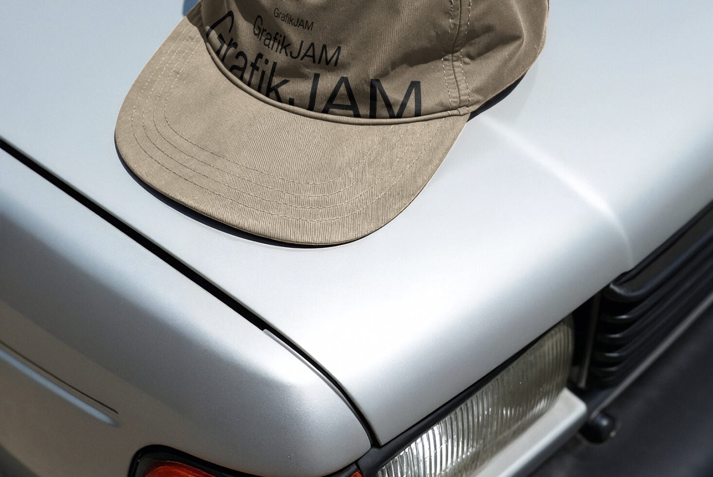 Tan baseball cap front brim close-up showing embroidered text detail