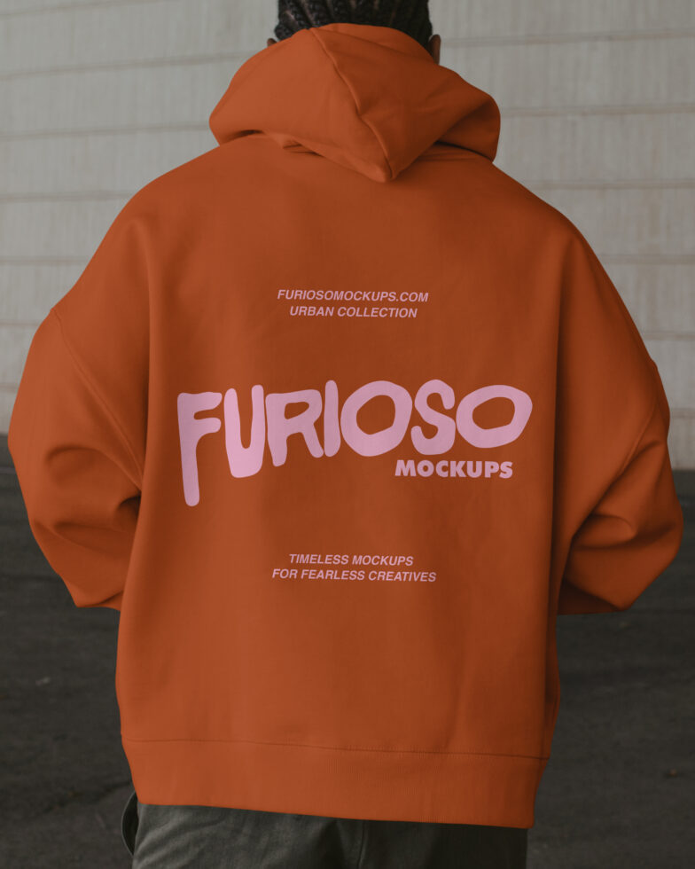 Rust hoodie back view with pink logo, concrete backdrop