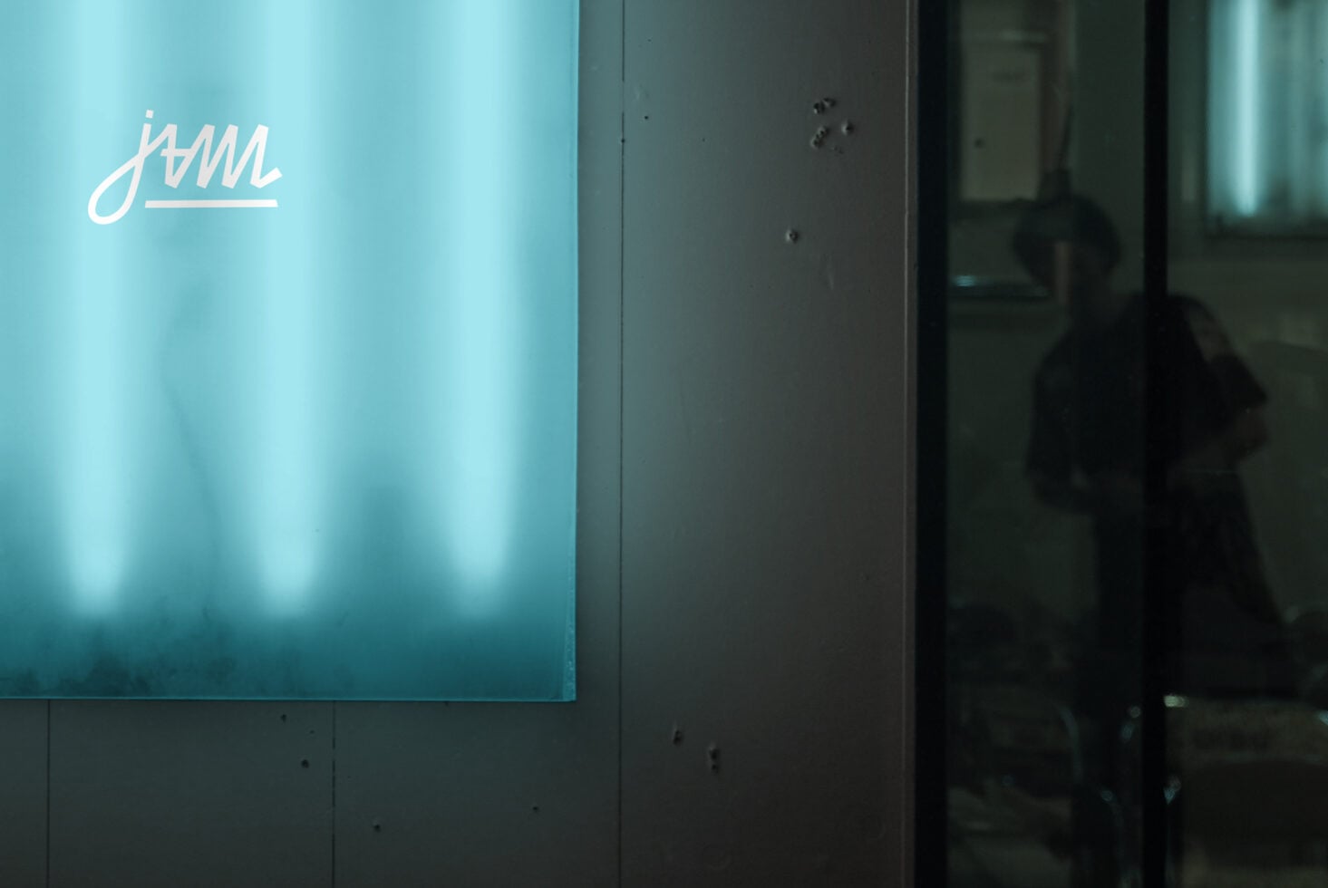 Bright turquoise neon sign with cursive script on modern wall