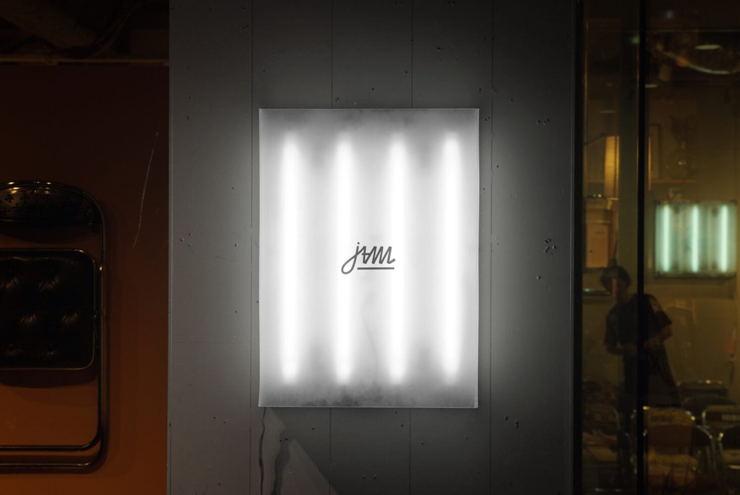 White neon glowing script on illuminated poster mounted indoors
