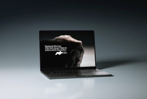 Macbook laptop displaying snowy peak mountain image with text overlay on blue background