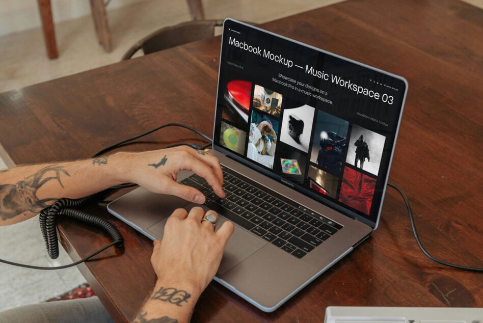 Macbook Pro on workspace showing music portfolio mockup on dark background screen
