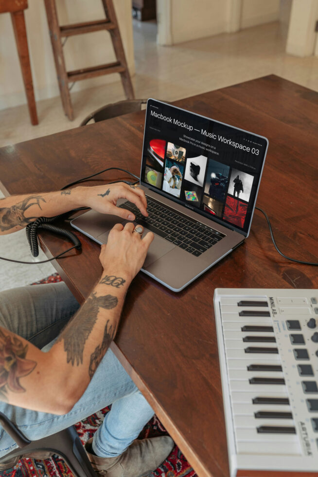 Macbook Pro on wooden desk showing music workspace mockup with keyboard, coiled cable nearby