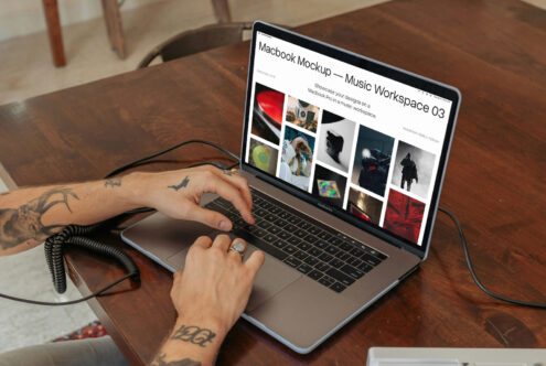 Macbook Pro angled on wood table displaying music workspace mockup with portfolio images