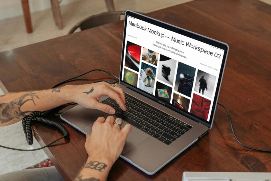 Macbook Pro angled on wood table displaying music workspace mockup with portfolio images