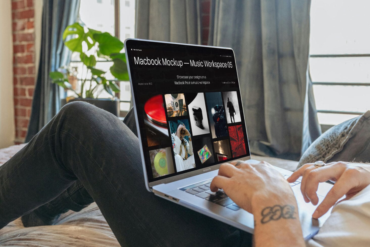 Macbook Pro screen showing dark music workspace mockup with portfolio grid layout by window