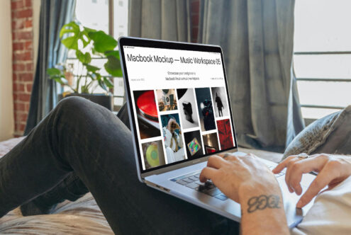 Person using Macbook Pro showing music workspace mockup with portfolio grid on bright white background