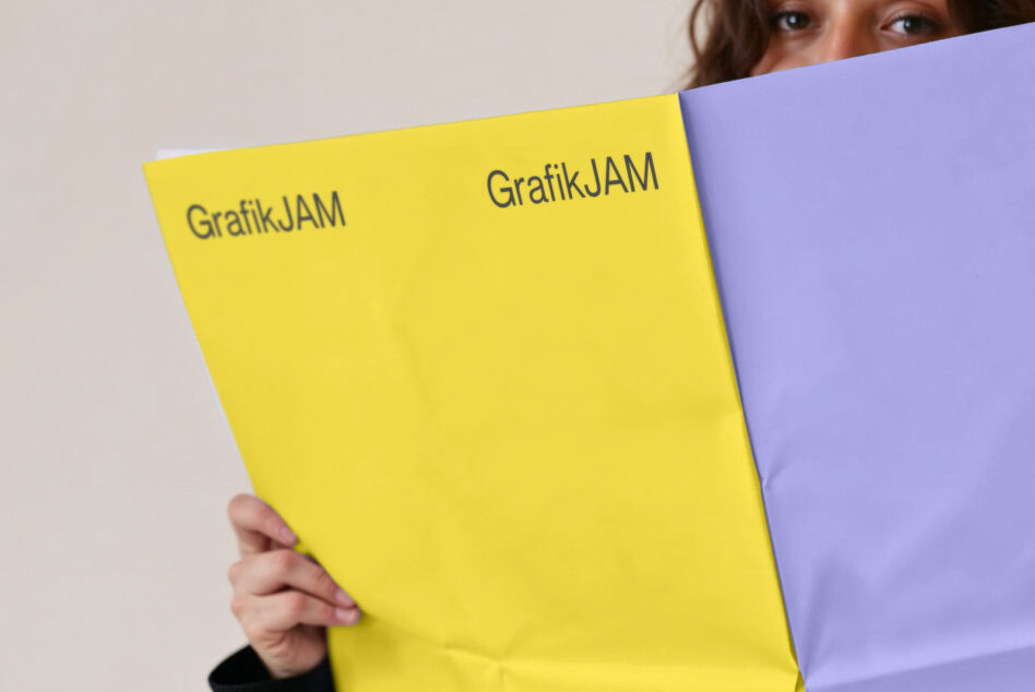 Woman holding open magazine spread, yellow left page, lavender right page both branded